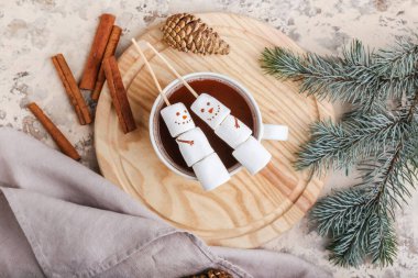 Yumuşak şekerlerden yapılmış kardan adamlar ve grunge arkaplanda bir fincan sıcak çikolata.