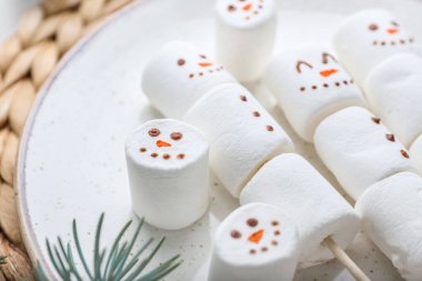 Tabaktaki yumuşak şekerlerden yapılmış kardan adamlar, yakın plan.