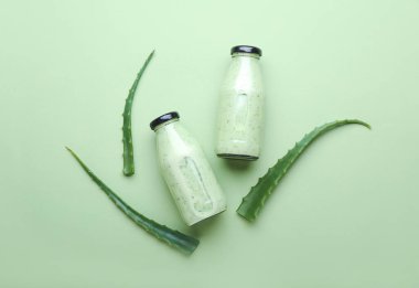 Renkli arkaplanda sağlıklı aloe suyu şişeleri