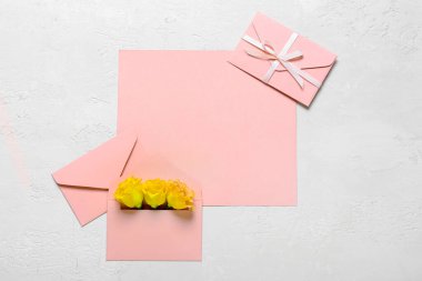 Beyaz arkaplanda güller olan boş kartlar ve zarflar