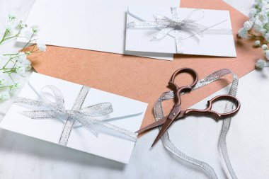 Beyaz arkaplanda zarflı, çiçekli ve makaslı kartlar