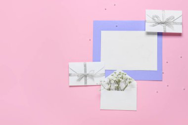 Boş kart ve pembe arka planda çiçekli zarflar