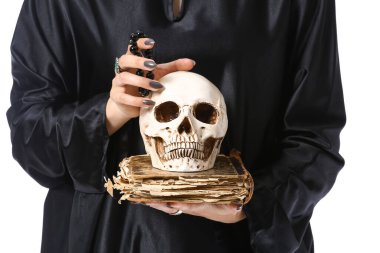 Kafatası ve büyü kitabı beyaz arka planda genç cadı, yakın plan