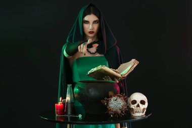 Witch performing ritual on black background clipart