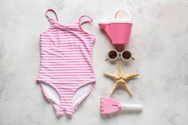 Çocuklar için plaj aksesuarları, şık bir mayo ve açık arkaplanda deniz yıldızı.