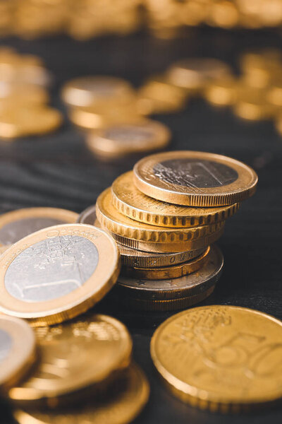 Golden coins on dark wooden background