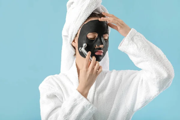 Mooie Jonge Vrouw Met Blad Gezichtsmasker Massage Tool Kleur Achtergrond — Stockfoto