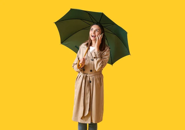 Schöne Junge Frau Mit Regenschirm Telefoniert Auf Farbigem Hintergrund — Stockfoto