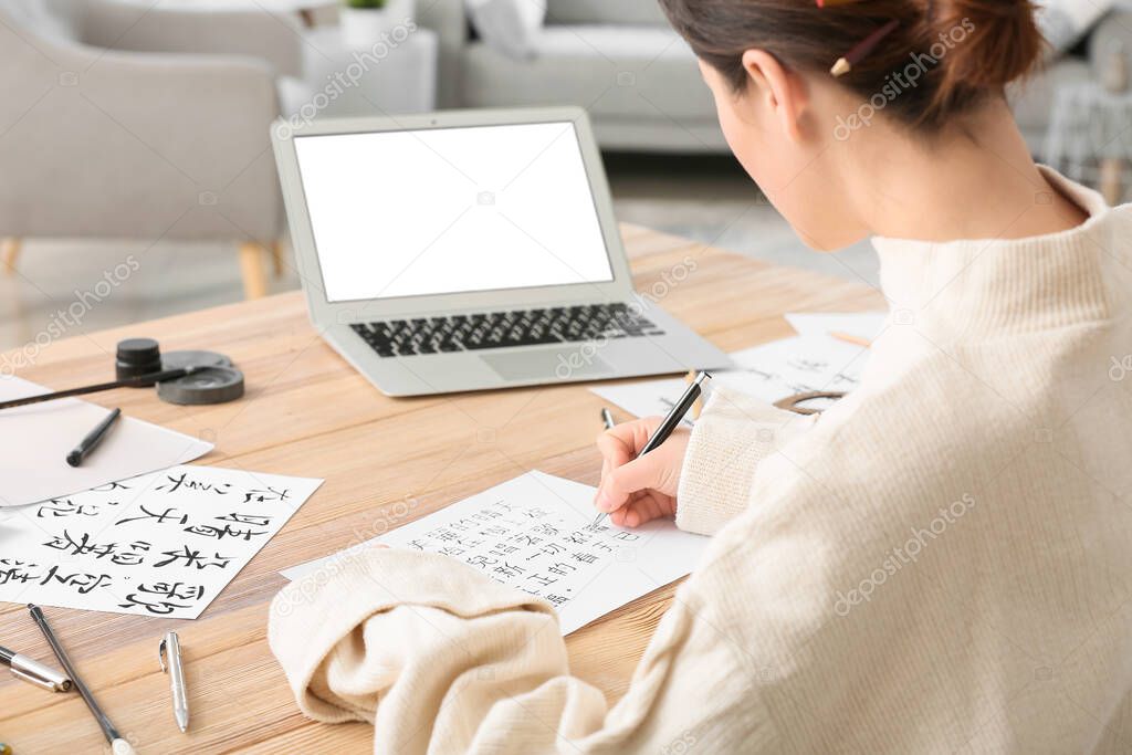 Female Asian calligraphist working in office