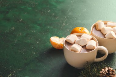 Renkli fonda sıcak kakao ve mandalina bardakları