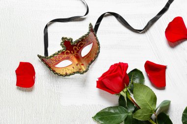 Beyaz arka planda güzel bir gül ve maskeli balo