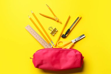 Sarı arka planda şık kalem kılıfı ve kırtasiye malzemesi