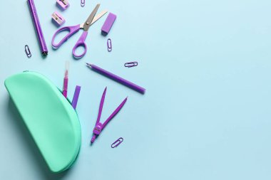 Mavi zemin üzerinde kalem kılıfı ve kırtasiye malzemesi olan kompozisyon