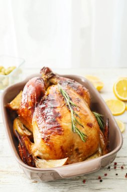 Hafif ahşap masada lezzetli tavuklu ve patatesli fırın tabağı, yakın plan.