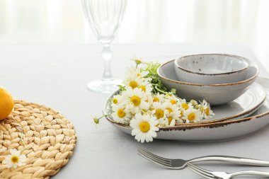 Yemek odasında şık masa dekorları ve papatya çiçekleri.