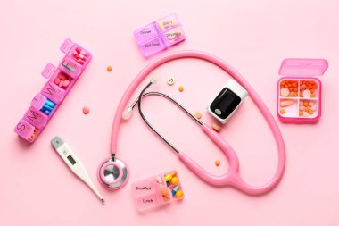 Nabız oksimetresi ve renk arkaplanındaki haplarla bileşim