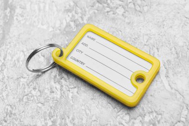 Grunge arka planında sarı plastik anahtar etiketi