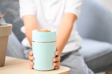 Masasında modern nemlendirici olan küçük çocuk.