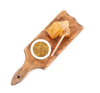 Beyaz arka planda bir kase arı poleni ve bal tarağı