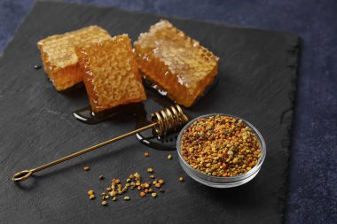 Siyah zemin üzerinde bal tarakları ve arı poleni olan tahta