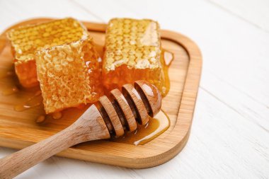 Beyaz ahşap zemin üzerinde bal tarakları olan tahta