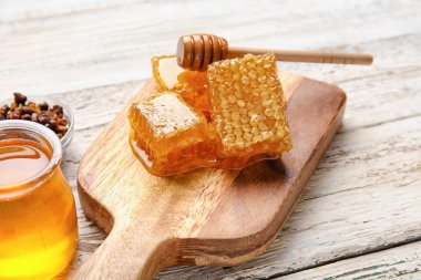 Beyaz ahşap zemin üzerinde bal tarakları olan tahta