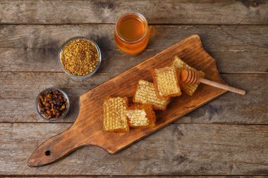 Tahta üzerinde bal tarakları ve arı ürünleri olan tahta kaplama