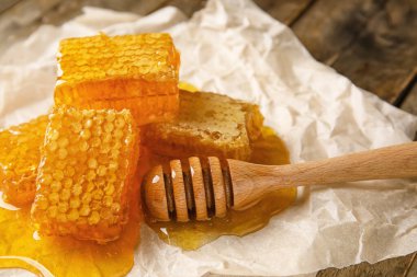 Ahşap arka planda bal tarakları ve kepçeler