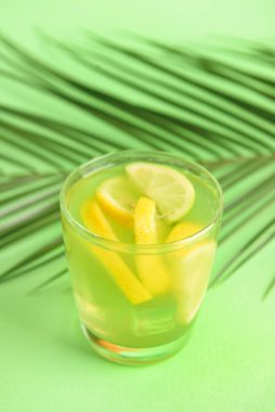 Renkli arkaplanda lezzetli limonatalı bardak