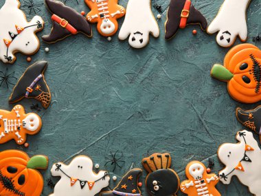 Koyu arkaplanda Cadılar Bayramı kutlaması için lezzetli kurabiyelerden yapılmış çerçeve