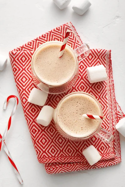 Composition with cups of hot cocoa drink and marshmallows on light background
