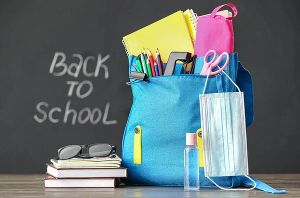 Schulrucksack Mit Schreibwaren Brille Medizinischer Maske Und Flasche Desinfektionsmittel Auf — Stockfoto