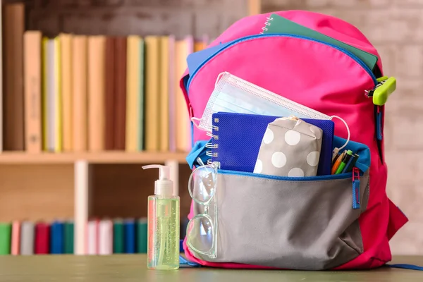 Mochila Escolar Con Papelería Anteojos Máscara Médica Botella Desinfectante Mesa —  Fotos de Stock