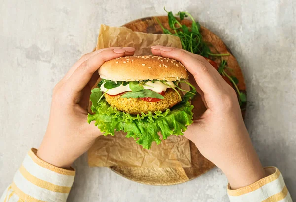 Frau Hält Leckeren Vegetarischen Burger Auf Grunge Hintergrund — Stockfoto