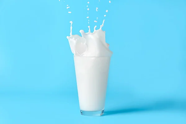 Склянка Молока Розбризкується Кольоровому Фоні — стокове фото