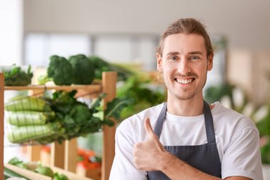 Pazarda taze sebzeli mutlu erkek satıcı