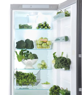 Beyaz arka planda yeşil sebzelerle dolu bir buzdolabı.