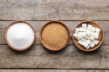 Tahta arka planda farklı şekerli kaseler