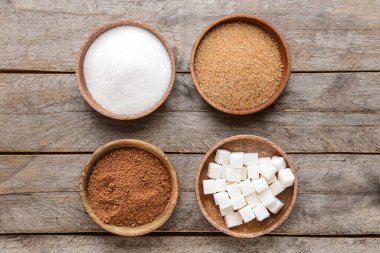 Tahta arka planda farklı şekerli kaseler