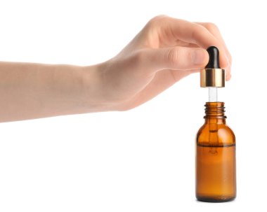 Beyaz arka planda sağlıklı bir yağ şişesi olan bir kadın eli.