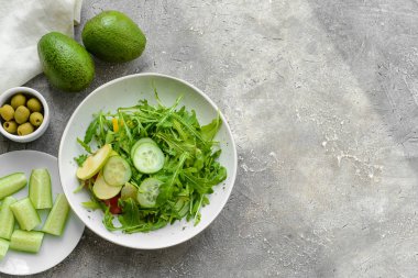 Gri arka planda sağlıklı salata tabağı.