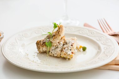 Lokantada lezzetli balık filetosu, pirinç ve sebze tabağı.