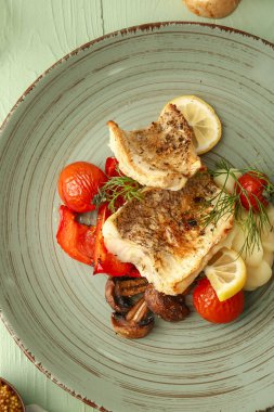 Lezzetli kızarmış balık filetosu, sebze ve ahşap arka planda patates püresi.