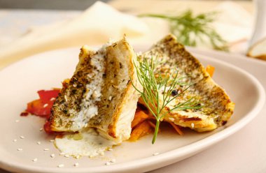 Lokantada lezzetli balık filetosu, sebze ve sos tabağı, yakın plan.