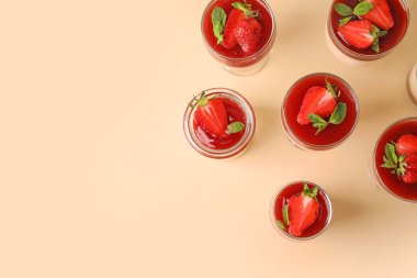 Çilekli lezzetli panna cotta ve renkli arka planda nane şekeri.