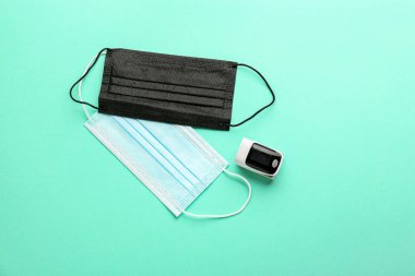 Renk arkaplanında nabız oksimetresi ve maskeler