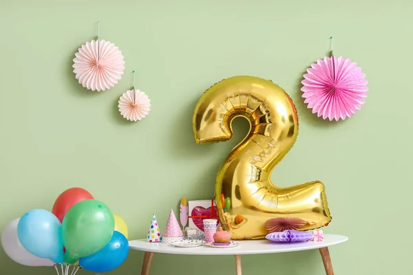 Table with air balloons and decor near color wall