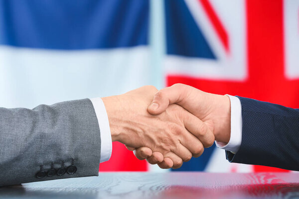Business people handshaking against the flags of Great Britain and France