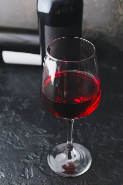 Glass of delicious red wine on dark background