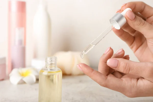 Mujer Aplicando Aceite Esencial Mano Sobre Fondo Claro — Foto de Stock